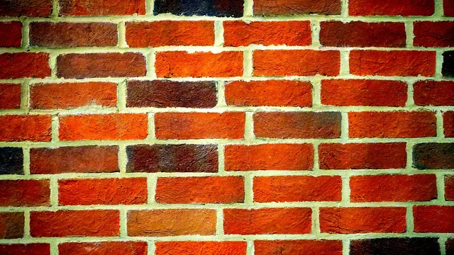 Mason repointing cracked mortar joints on a brick wall